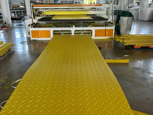 Yellow textured mats stacked beside production equipment