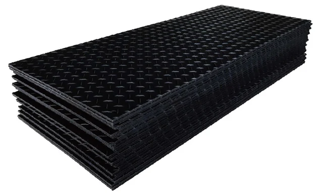 Stacked black ground protection mats with a textured tread